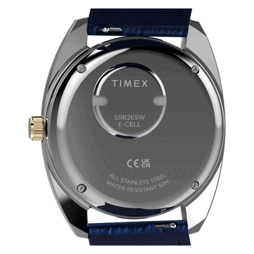 Altın tonlu Timex Q 1976 Day and Date'in paslanmaz çelik kasa arka kapağını, pil bölmesini ve 50 metre su geçirmezlik işaretini gösteren arkadan görünümü.