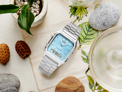 Casio AQ230A-2A1M, masa üstünde estetik bir şekilde stilize edilmiştir.