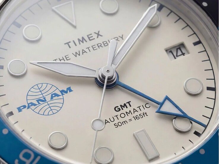 Timex Pan Am Waterbury Automatic GMT saatinin gümüş-beyaz kadranı, ışıklı saat işaretleri, tarih penceresi ve Pan Am markasını gösteren yakın çekim fotoğrafı.
