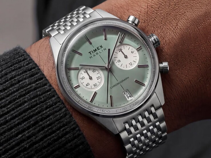 Bilek üzerinde takılı, adaçayı yeşili kadranlı ve paslanmaz çelik bilezikli Timex Marlin Jet Chronograph, bombeli camını ve yuvarlak, retro-fütürist kasa profilini sergiliyor.