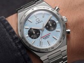 Timex Q Timex Continental Chronograph TW2Y92400 modelinin bileğe takılmış halinin yakın çekimi; saat, buz mavisi radyal CD tarzı kadran, siyah alt kadranlar, gümüş takimetre çerçeve ve entegre paslanmaz çelik bilezik ile donatılmıştır.
