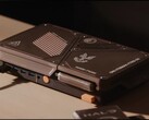 Masa üzerinde duran, mini bir bilgisayar, açıkta bulunan soğutma delikleri, USB bağlantı noktaları ve turuncu renkli güç düğmelerine sahip, özel olarak tasarlanmış kompakt bir oyun konsolu.