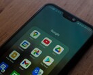 Google uygulamaları klasörü açık halde ahşap bir masanın üzerinde duran akıllı telefon