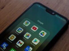 Google uygulamaları klasörü açık halde ahşap bir masanın üzerinde duran akıllı telefon