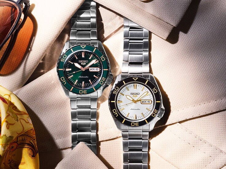 Seiko 5 Sports SKX HDB004 ve HDB005 saatleri kumaş üzerinde yan yana sergileniyor; beyaz-siyah HDB004 ve yeşil-roz altın HDB005 görülüyor.