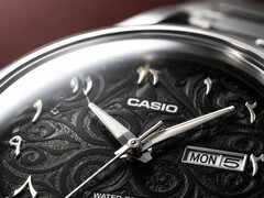 Casio MTP-E735AR’nin karmaşık arabesk desenli, kabartmalı Doğu Arap rakamlarına, cilalı gümüş tonlu ibrelere ve saat 3 konumunda gün-tarih göstergesine sahip siyah kadranının yakın çekimi.