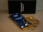 Trump Phone T1'in kutusu ve kablosuyla birlikte bir fotoğrafı.
