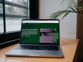 Pencerenin yanındaki masanın üzerinde, ekranında OpenAI ChatGPT web sitesi açık olan bir dizüstü bilgisayar