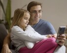 Bir baba ve kızı birlikte bir akıllı telefona bakıyor