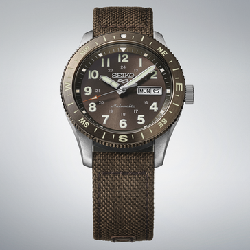 Kahverengi kadranlı, pusula çerçeveli ve kahverengi naylon kayışlı Seiko 5 Sports HDB009 otomatik saha saati.