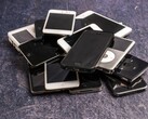 Gri bir yüzey üzerinde birikmiş emekli akıllı telefonlar