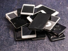 Gri bir yüzey üzerinde birikmiş emekli akıllı telefonlar