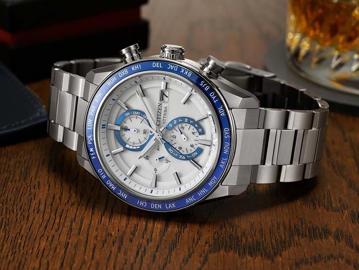 Lacivert kadranı, rose gold detayları ve siyah dünya saati bezeli görünen Citizen Attesa AT8297-51L kronograf, ahşap bir masanın üzerinde duruyor.