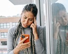 Bir kadın ciddi bir ifadeyle akıllı telefonuna bakıyor